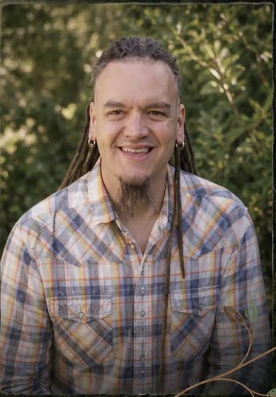 David K Juniper smiling in a sunlit garden.